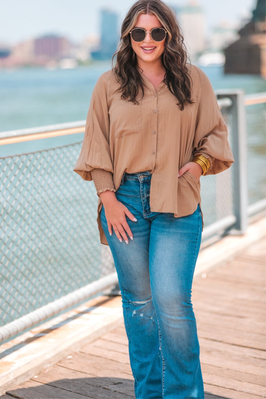 long-sleeve unlined top with a collared neckline, smocked wrists, button down front closure, functional side pockets, a chest pocket, a high-low hemline, and a relaxed fit designed on vertical stripe fabric in taupe