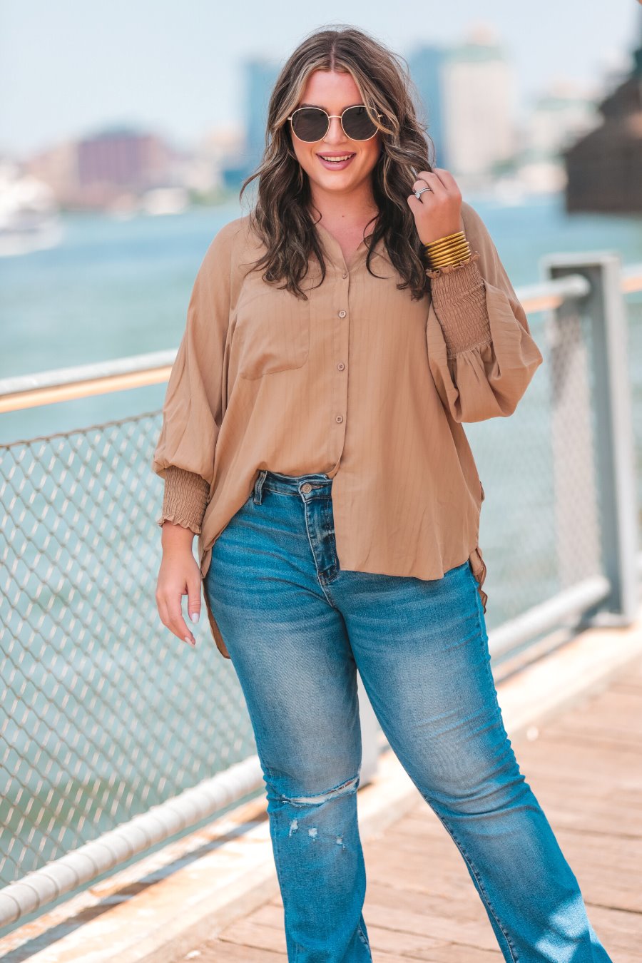 long-sleeve unlined top with a collared neckline, smocked wrists, button down front closure, functional side pockets, a chest pocket, a high-low hemline, and a relaxed fit designed on vertical stripe fabric in taupe