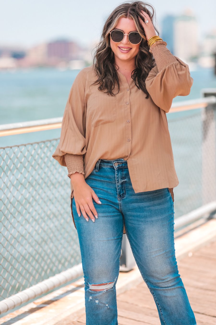 long-sleeve unlined top with a collared neckline, smocked wrists, button down front closure, functional side pockets, a chest pocket, a high-low hemline, and a relaxed fit designed on vertical stripe fabric in taupe