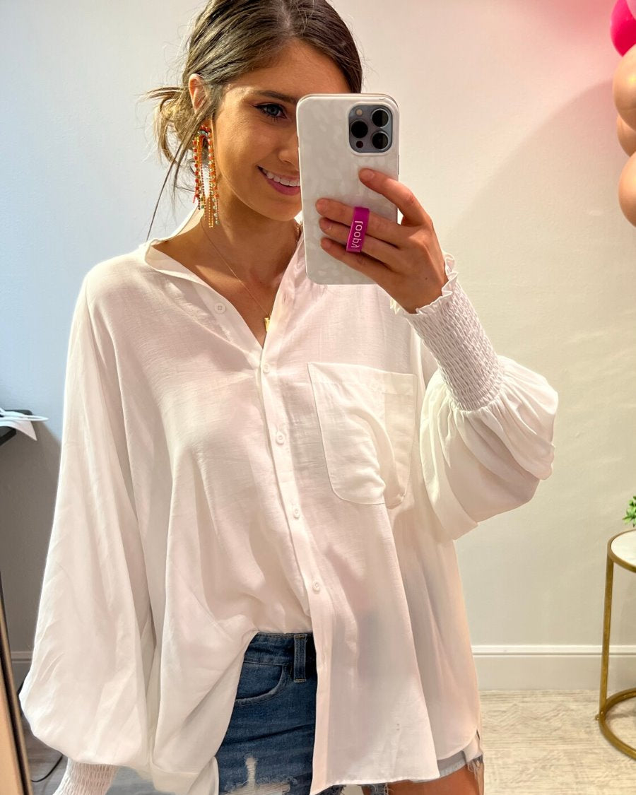 long-sleeve unlined top with a collared neckline, smocked wrists, button down front closure, functional side pockets, a chest pocket, a high-low hemline, and a relaxed fit designed on vertical stripe fabric in ivory