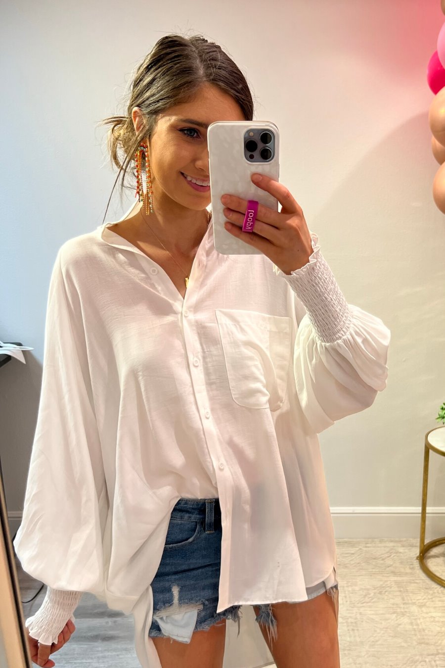 long-sleeve unlined top with a collared neckline, smocked wrists, button down front closure, functional side pockets, a chest pocket, a high-low hemline, and a relaxed fit designed on vertical stripe fabric in ivory