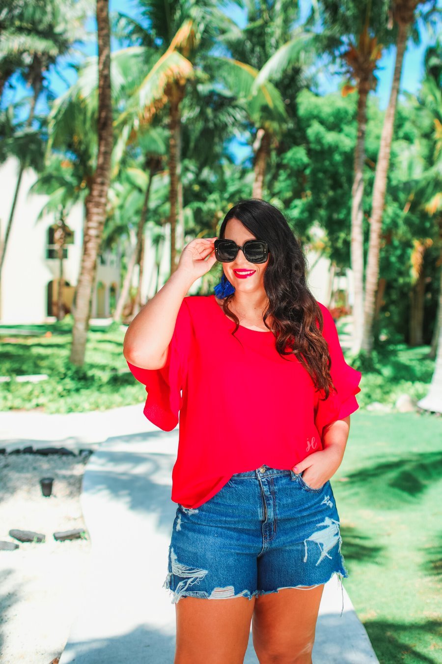 a red true-to-size blouse crafted from lightweight textured fabric with a rounded neckline, tiered ruffle sleeves, and a relaxed drape