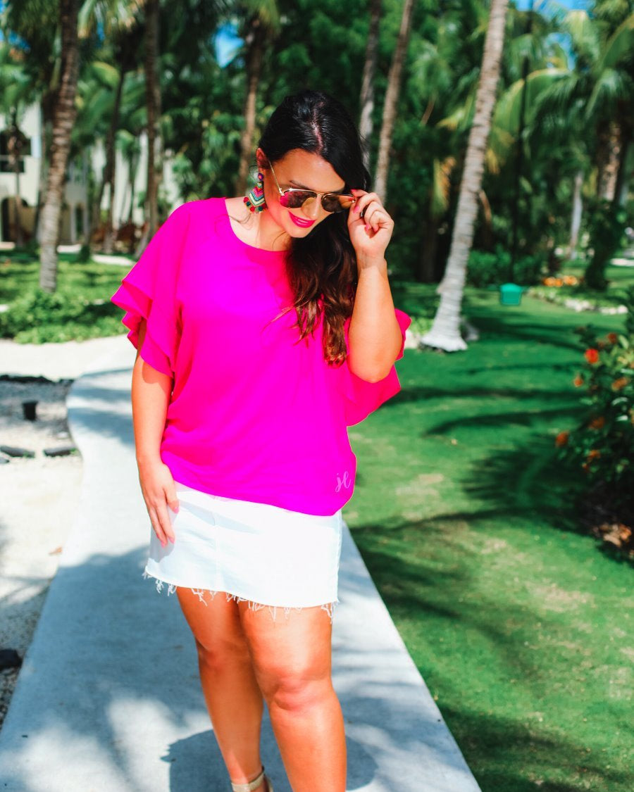a pink true-to-size blouse crafted from lightweight textured fabric with a rounded neckline, tiered ruffle sleeves, and a relaxed drape