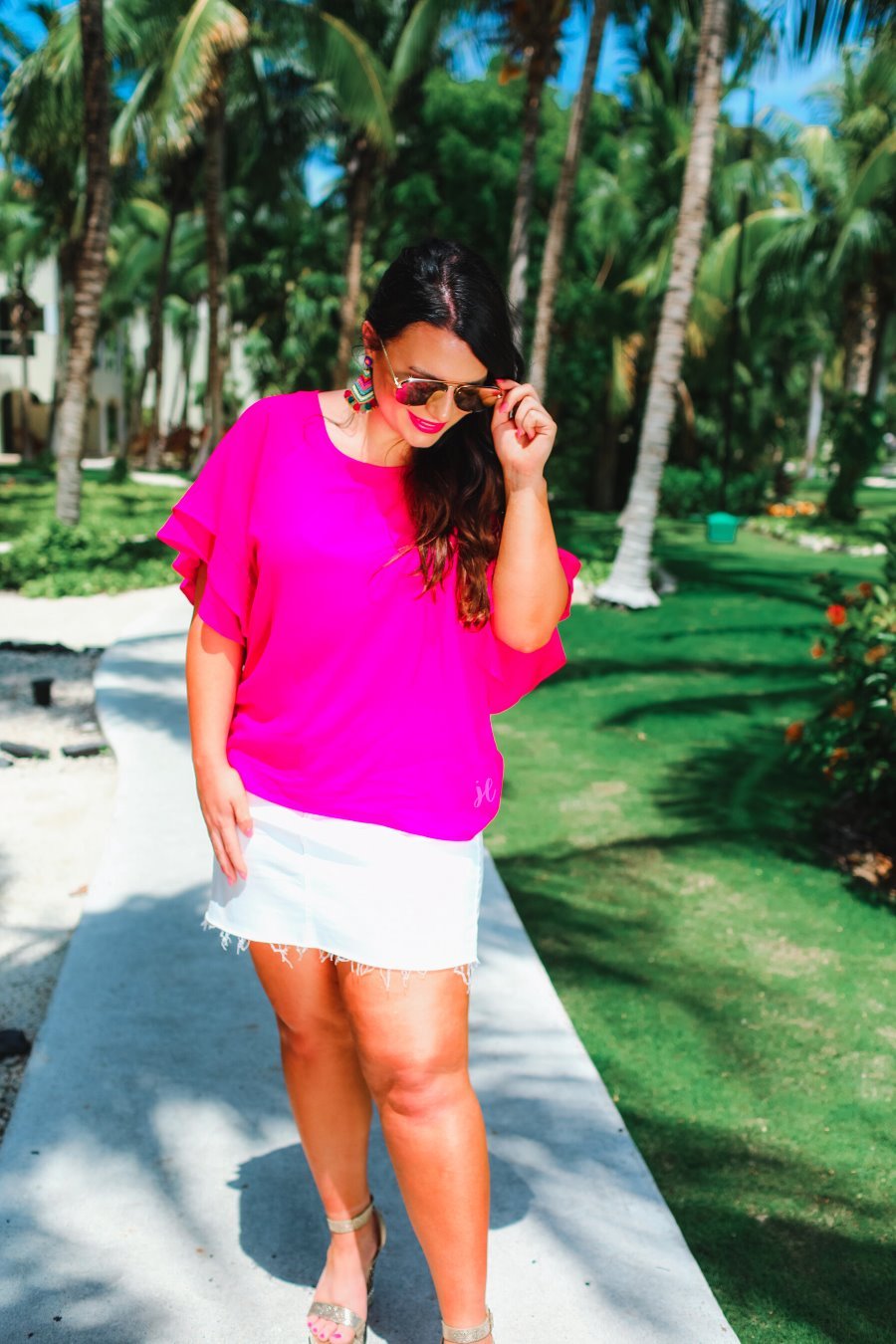 a pink true-to-size blouse crafted from lightweight textured fabric with a rounded neckline, tiered ruffle sleeves, and a relaxed drape