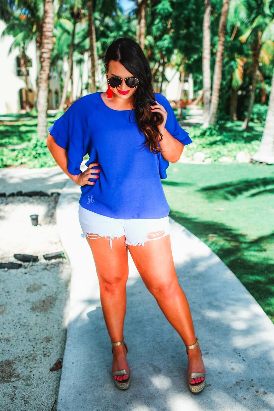 a blue true-to-size blouse crafted from lightweight textured fabric with a rounded neckline, tiered ruffle sleeves, and a relaxed drape