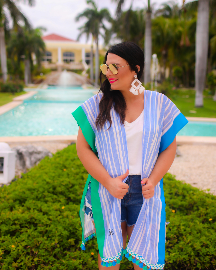 a loose-flowy fit kimono crafted from lightweight fabric with an open-front style, pom pom detailing, colored sides, and contrasting panels