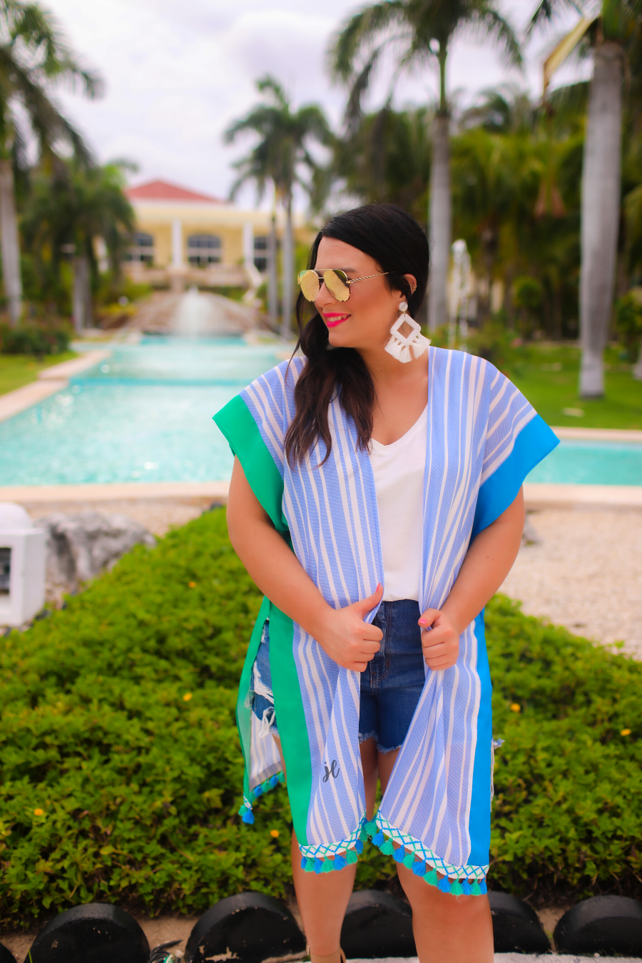 a loose-flowy fit kimono crafted from lightweight fabric with an open-front style, pom pom detailing, colored sides, and contrasting panels