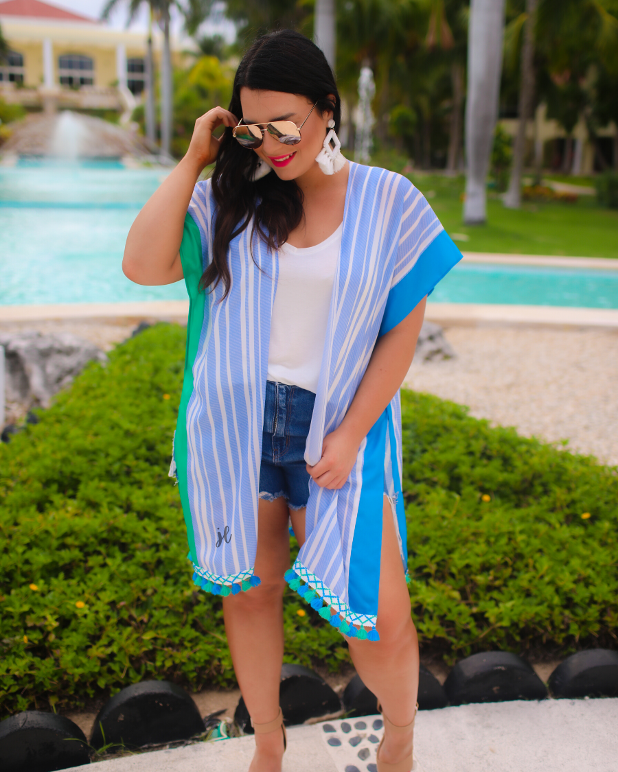 a loose-flowy fit kimono crafted from lightweight fabric with an open-front style, pom pom detailing, colored sides, and contrasting panels