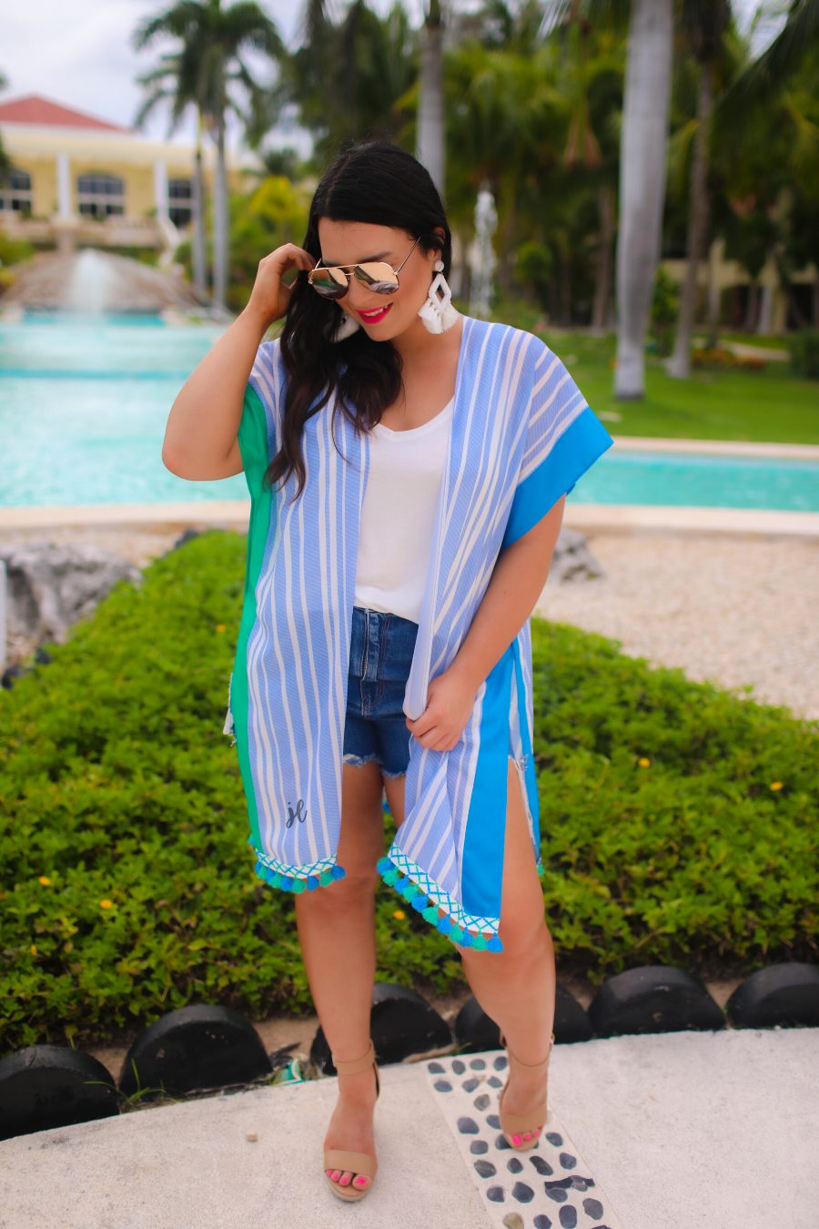 a loose-flowy fit kimono crafted from lightweight fabric with an open-front style, pom pom detailing, colored sides, and contrasting panels