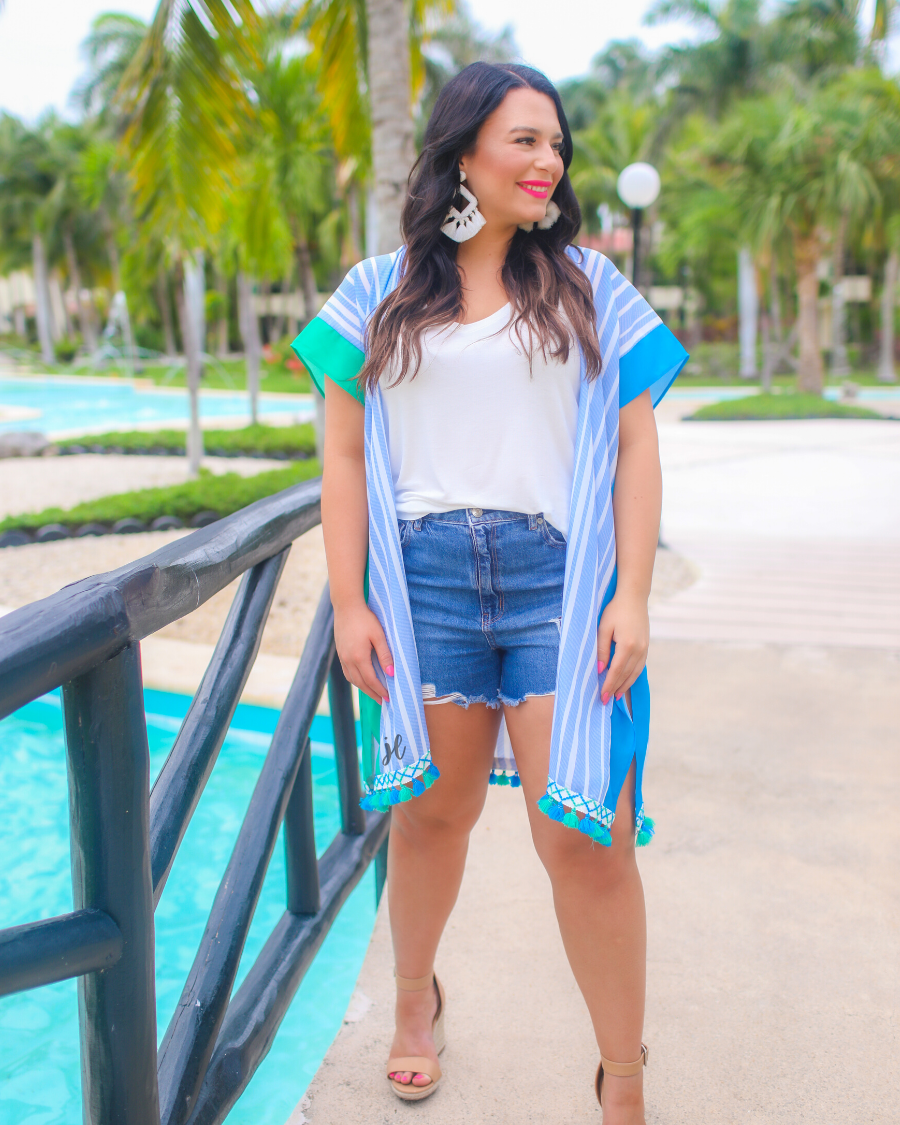 a loose-flowy fit kimono crafted from lightweight fabric with an open-front style, pom pom detailing, colored sides, and contrasting panels