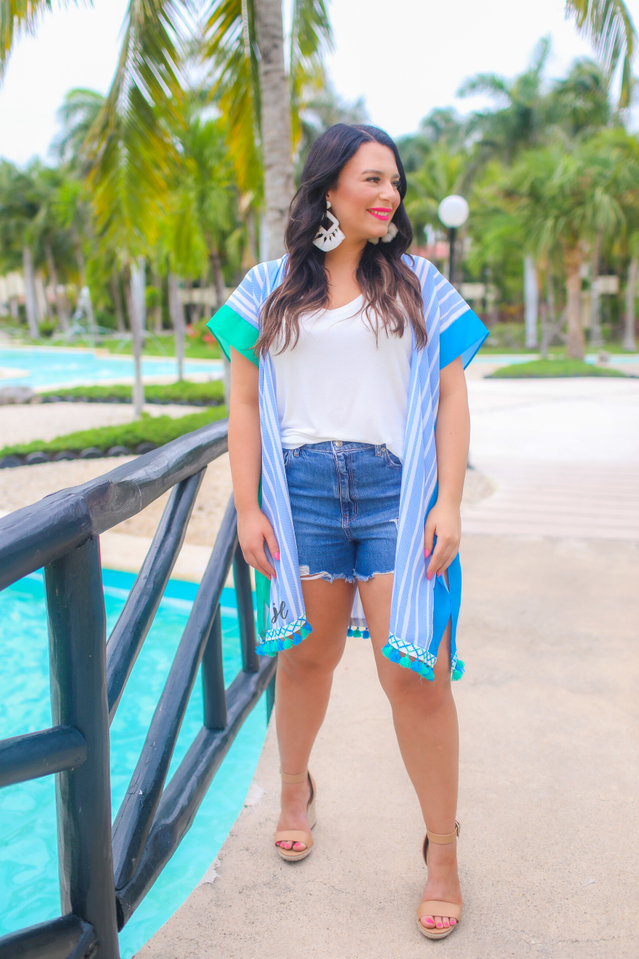 a loose-flowy fit kimono crafted from lightweight fabric with an open-front style, pom pom detailing, colored sides, and contrasting panels