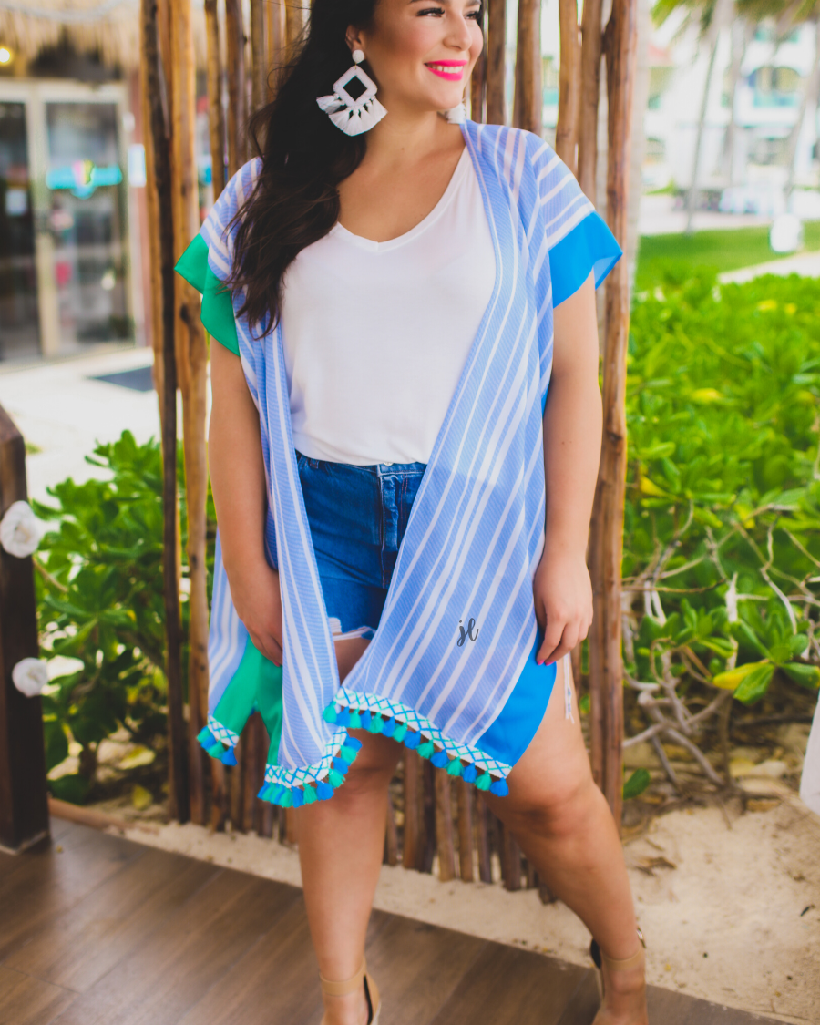 a loose-flowy fit kimono crafted from lightweight fabric with an open-front style, pom pom detailing, colored sides, and contrasting panels in blue
