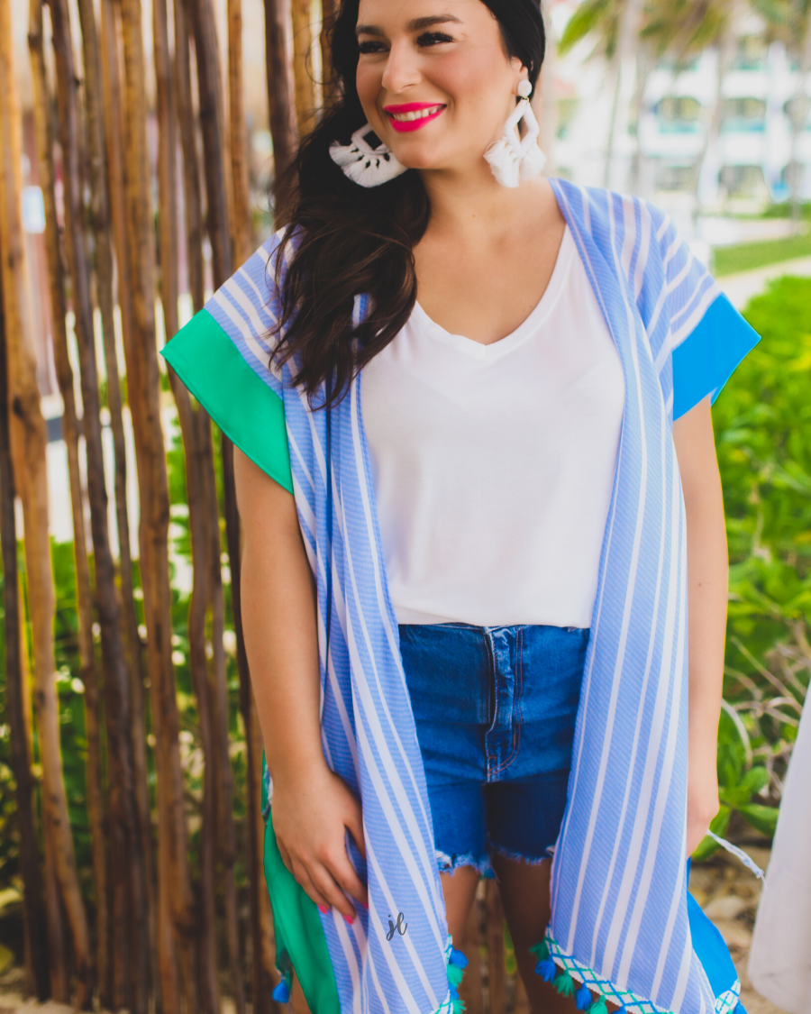 a loose-flowy fit kimono crafted from lightweight fabric with an open-front style, pom pom detailing, colored sides, and contrasting panels