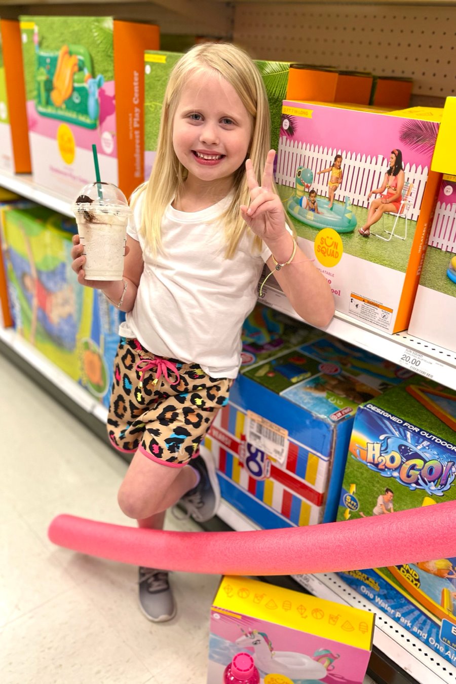 mid-rise relaxed fit activewear shorts with side pockets and a tie waist drawstring with gold bead accents, designed on a vibrant multicolor leopard pattern print fabric, tan base, and pink trim