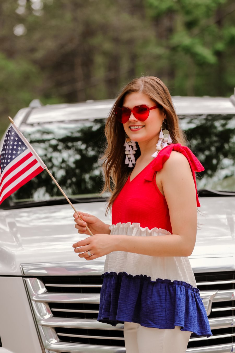 a red tiered color block top with a V-neckline front and back, adjustable wide tie straps, a ruffled hem, and a relaxed, lightweight fit