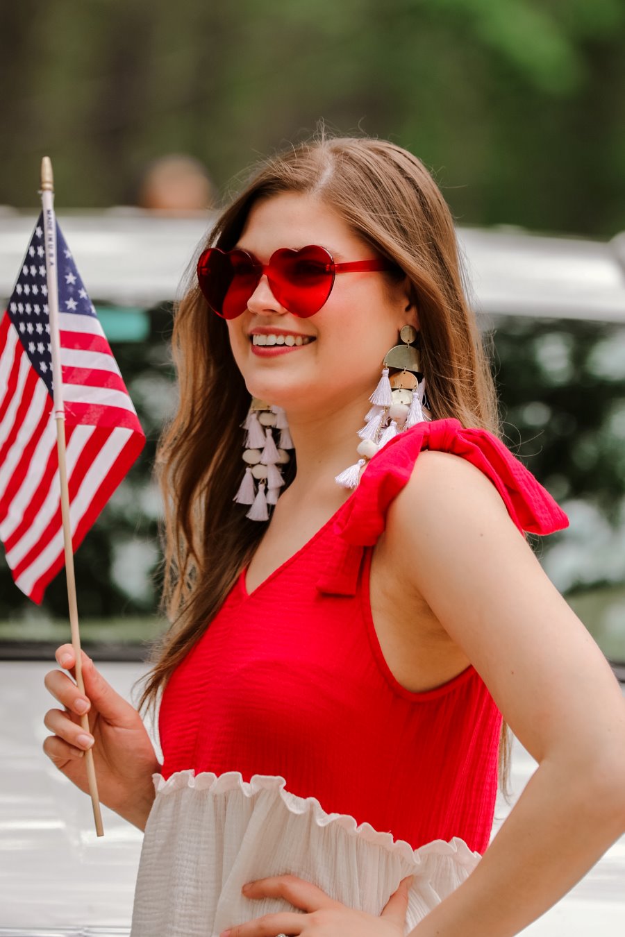 a red tiered color block top with a V-neckline front and back, adjustable wide tie straps, a ruffled hem, and a relaxed, lightweight fit
