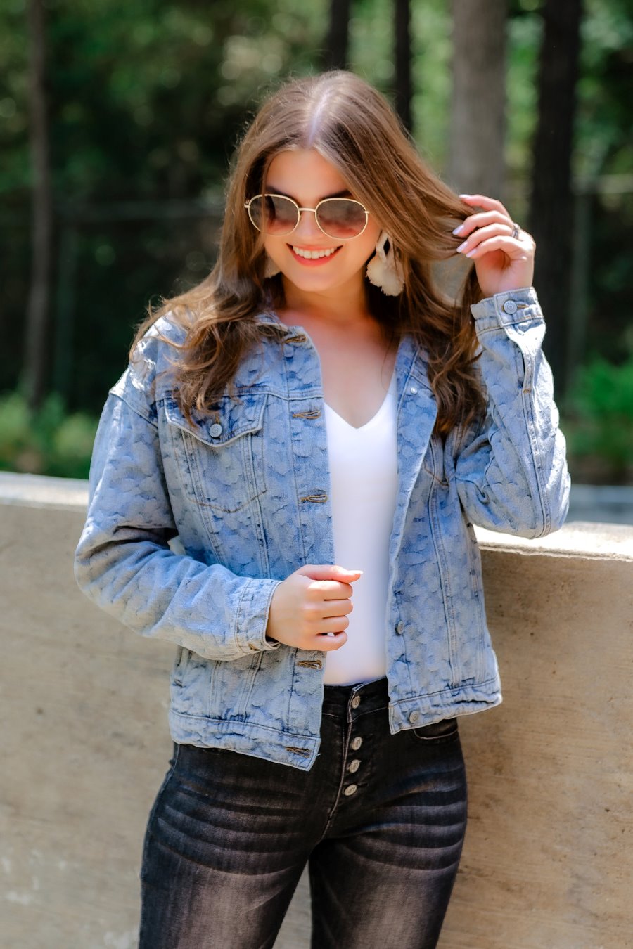 relaxed-fit jacket crafted from light wash denim with subtle distressing and faded leopard print accents, a button-down front, collared neckline, flap chest pockets, rollable long sleeves with buttoned cuffs, and a straight hemline