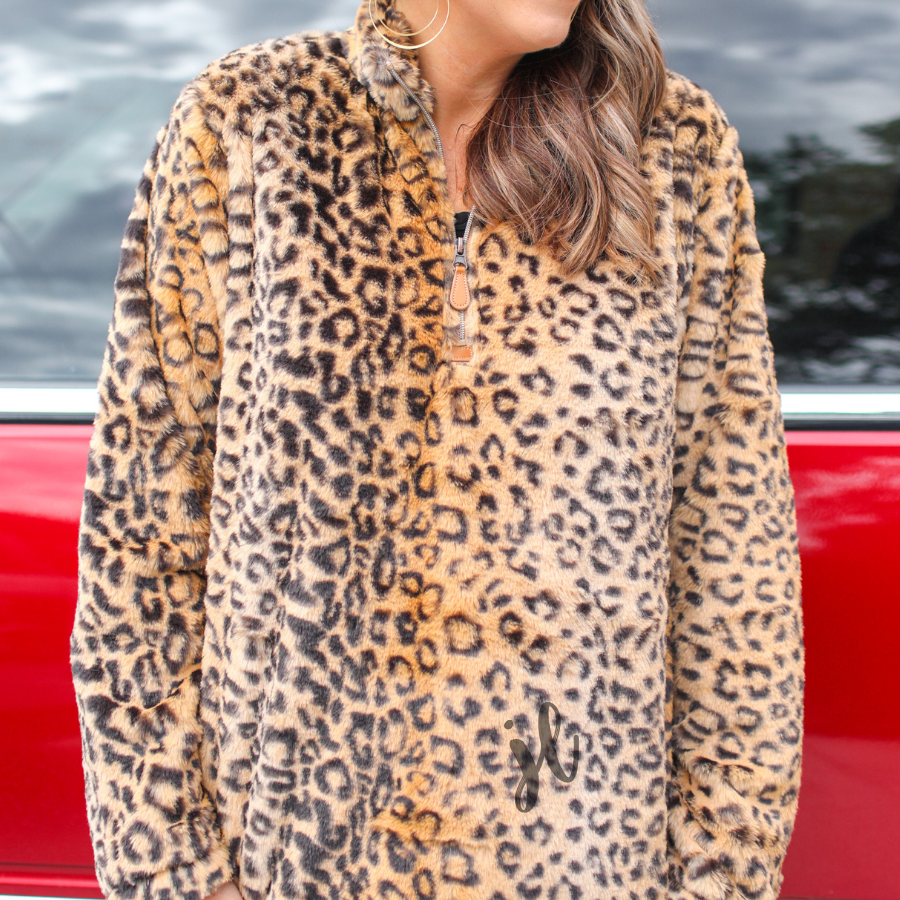 a long-sleeve fluffy pullover with a quarter zip and a foldable collar on a brown leopard fabric that fits oversized