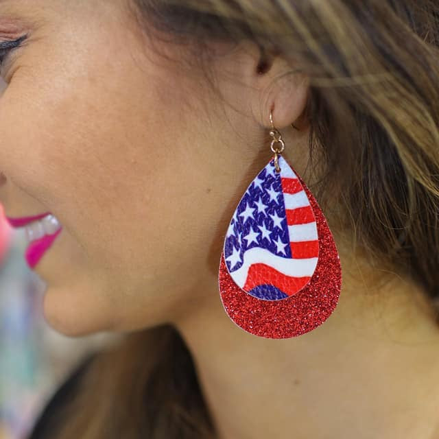 layered teardrop fishhook back earrings adorned with one small drop (American flag teardrop and white felt backing), one large double-sided glitter drop, and gold accents