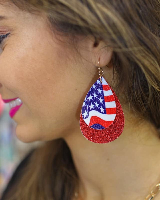 layered teardrop fishhook back earrings adorned with one small drop (American flag teardrop and white felt backing), one large double-sided glitter drop, and gold accents