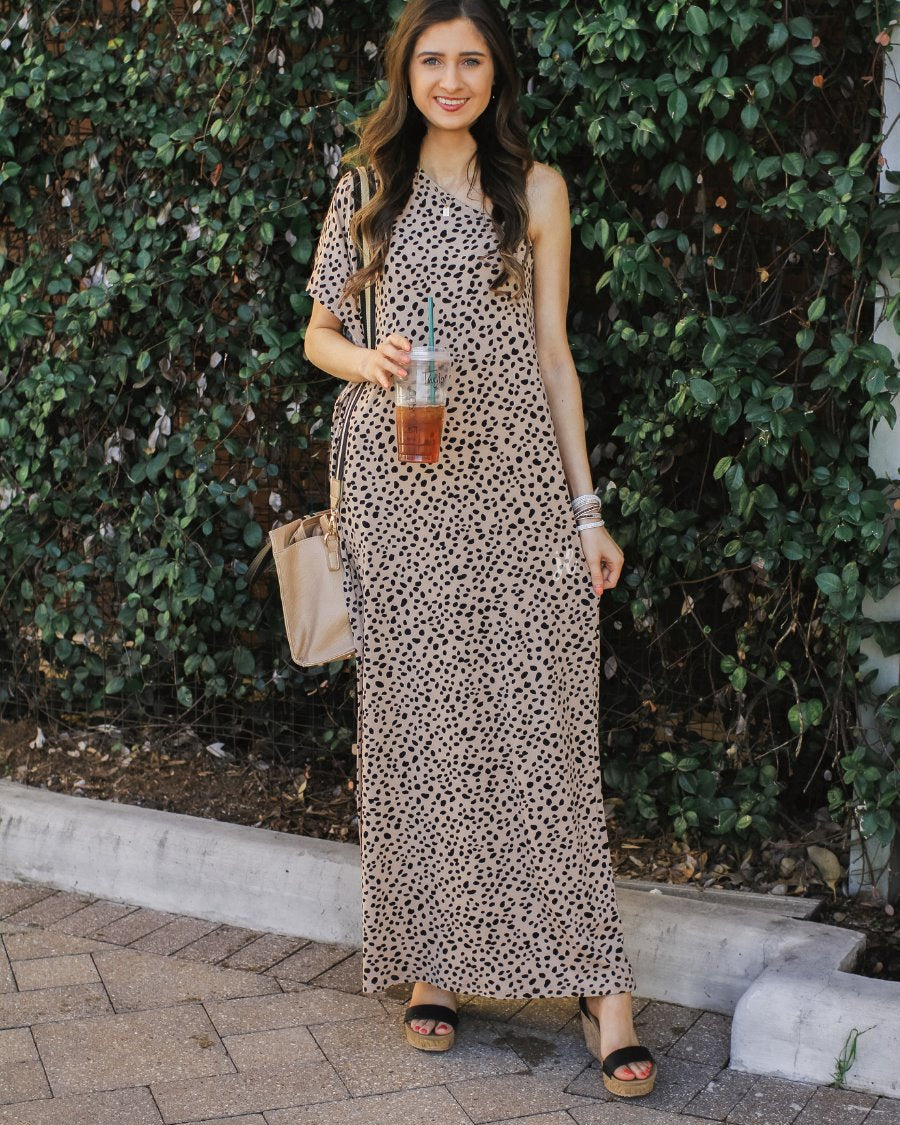 a maxi dress with a trendy one-shoulder neckline, a relaxed short sleeve, functional side pockets, subtle side slits, and square hemline on a black leopard pattern and taupe base