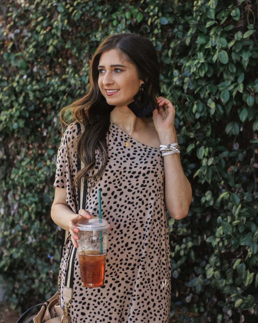 a maxi dress with a trendy one-shoulder neckline, a relaxed short sleeve, functional side pockets, subtle side slits, and square hemline on a black leopard pattern and taupe base