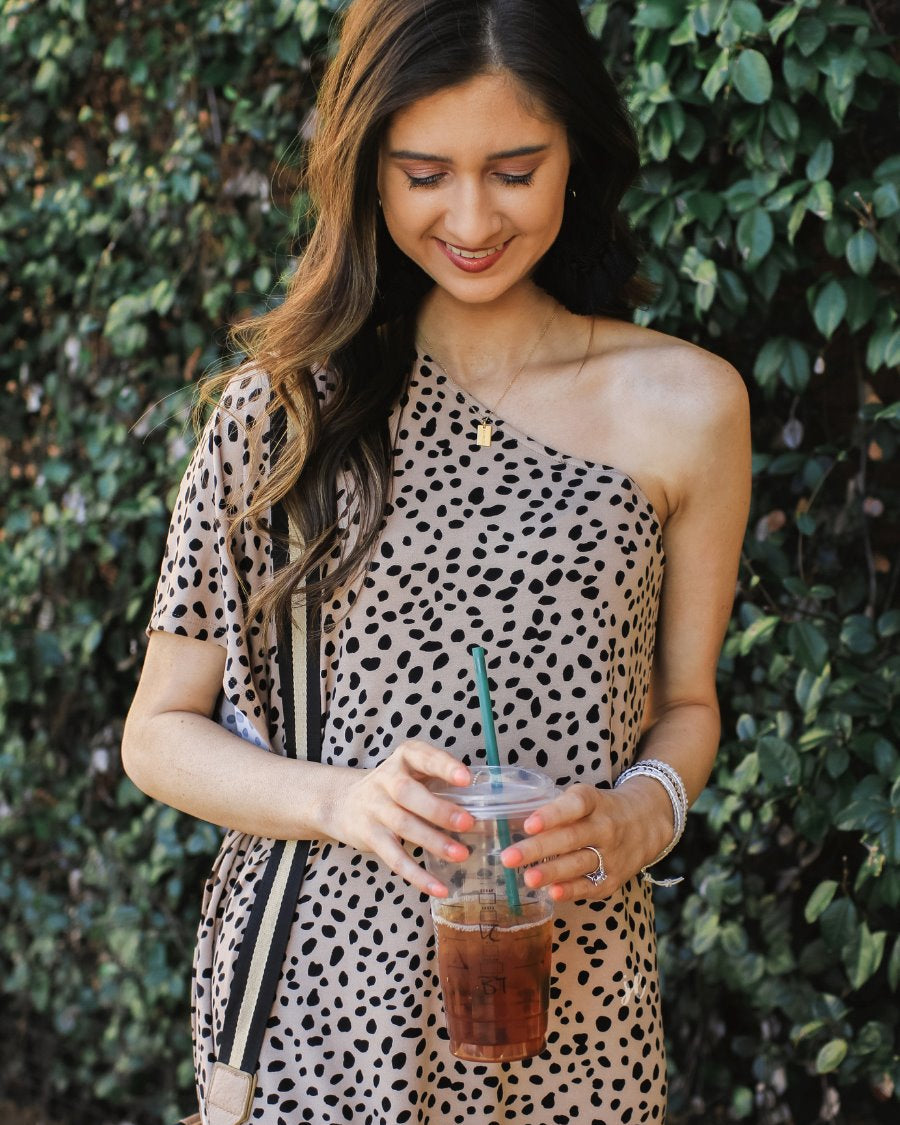 a maxi dress with a trendy one-shoulder neckline, a relaxed short sleeve, functional side pockets, subtle side slits, and square hemline on a black leopard pattern and taupe base