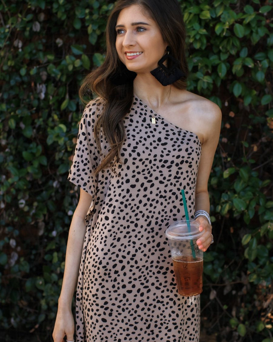 a maxi dress with a trendy one-shoulder neckline, a relaxed short sleeve, functional side pockets, subtle side slits, and square hemline on a black leopard pattern and taupe base
