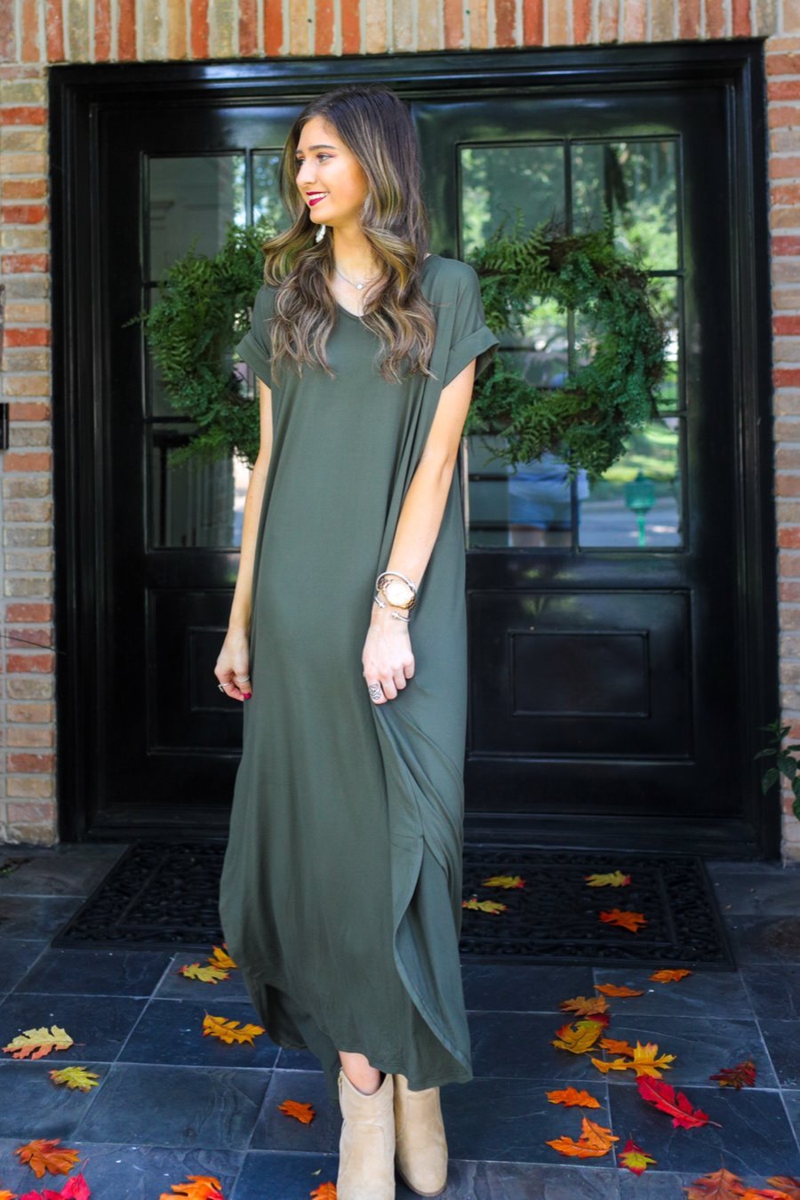 oversized short-sleeve t-shirt dress crafted from soft, stretchy material with a V-neckline, cuffed sleeves, side slits, and pockets on a solid olive fabric