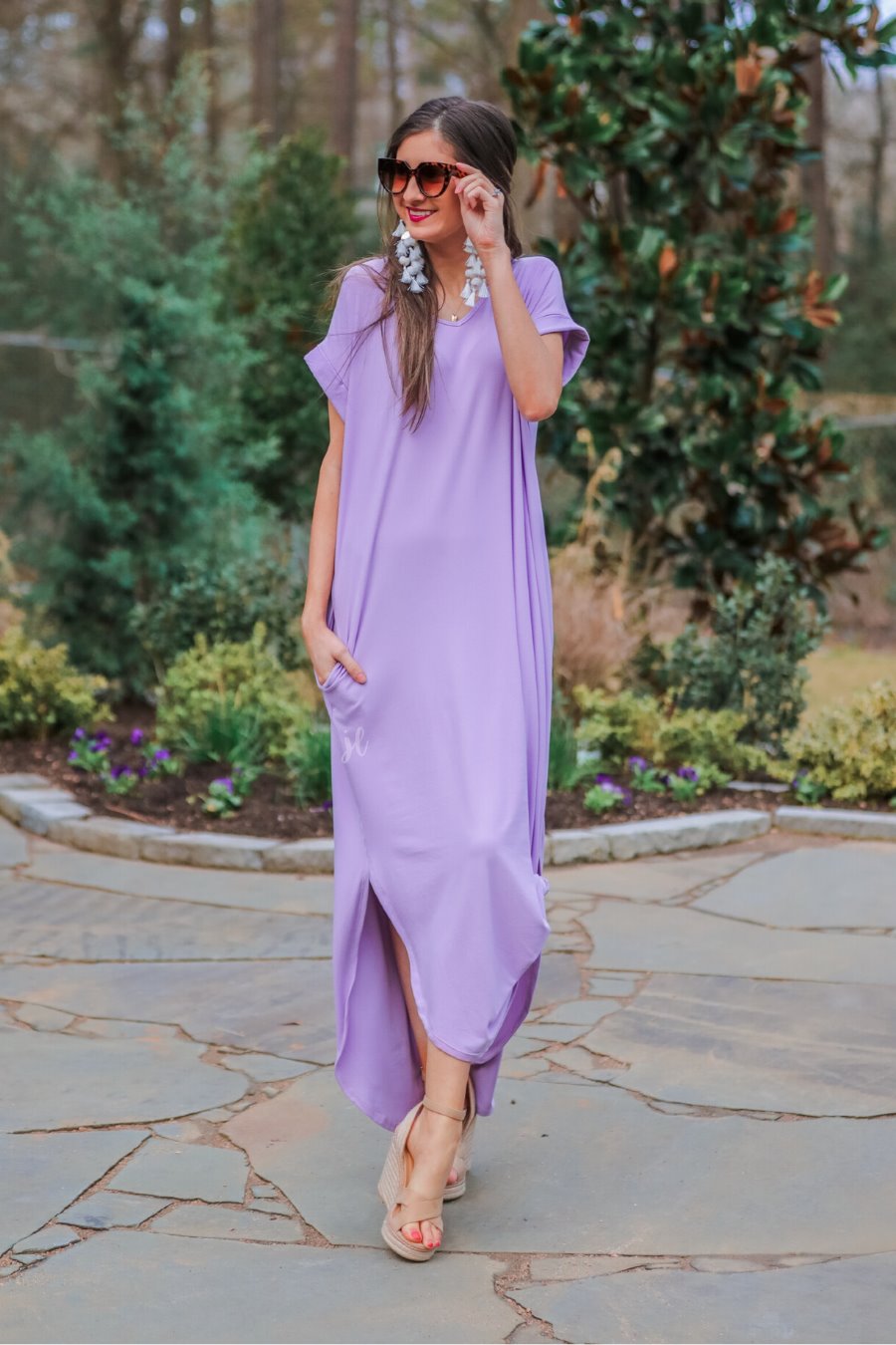 oversized short-sleeve t-shirt dress crafted from soft, stretchy material with a V-neckline, cuffed sleeves, side slits, and pockets on a solid lavender fabric