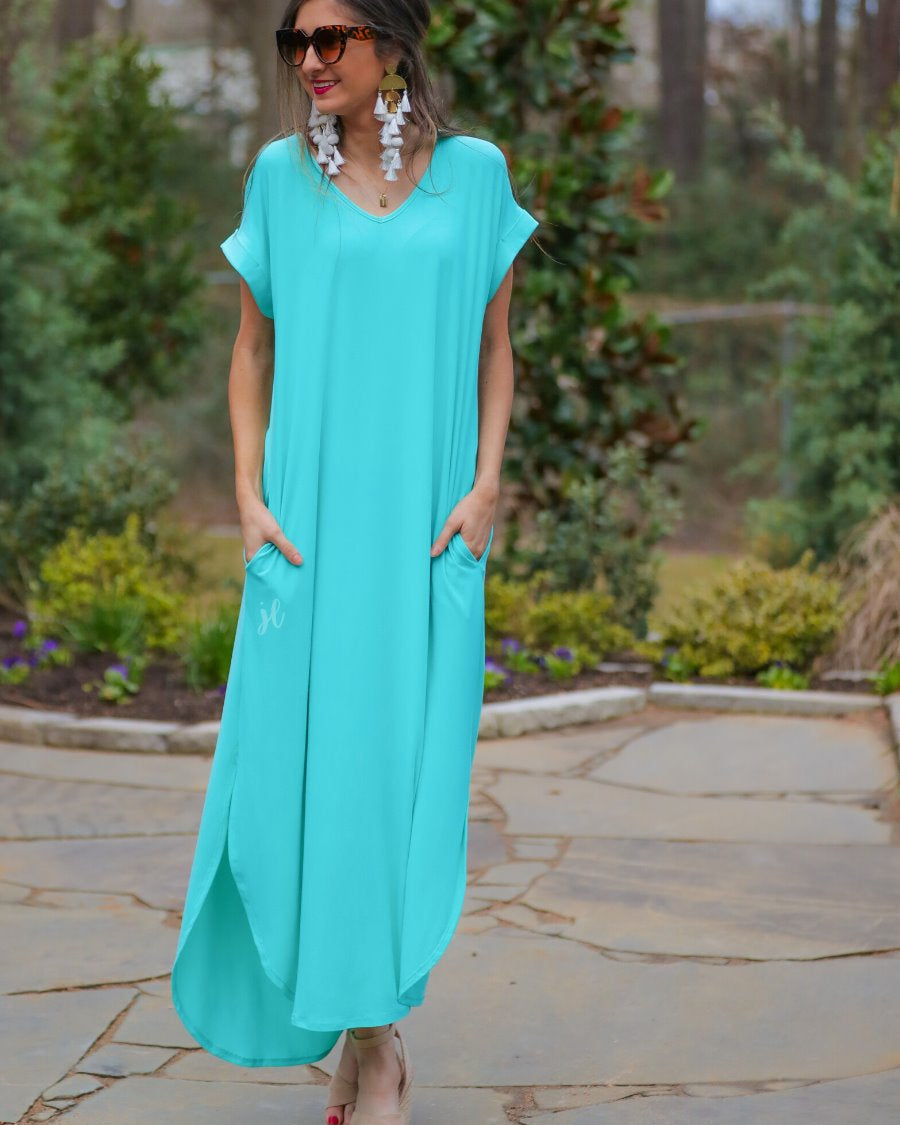 oversized short-sleeve t-shirt dress crafted from soft, stretchy material with a V-neckline, cuffed sleeves, side slits, and pockets on a solid mint fabric