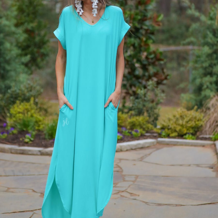 oversized short-sleeve t-shirt dress crafted from soft, stretchy material with a V-neckline, cuffed sleeves, side slits, and pockets on a solid mint fabric