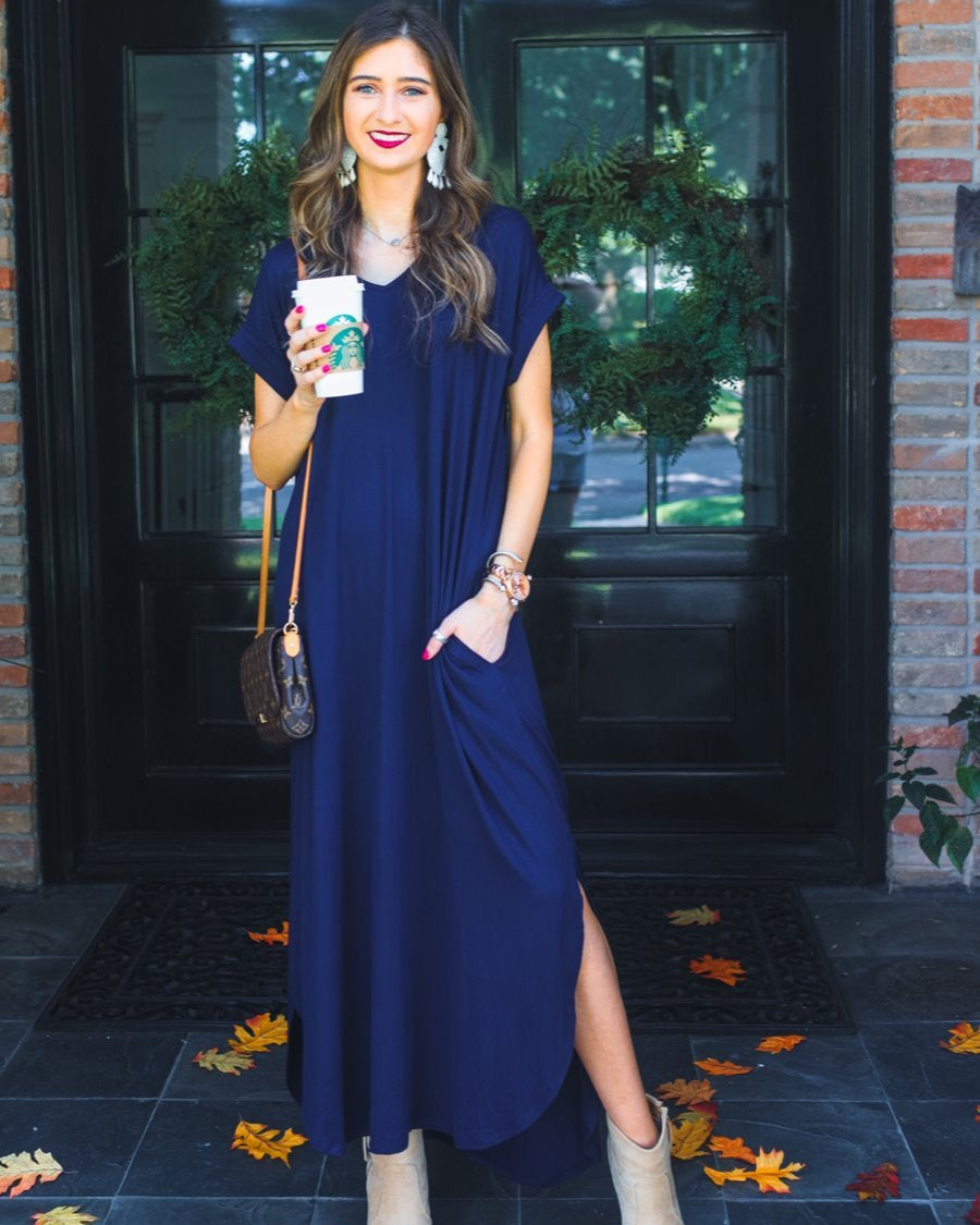 oversized short-sleeve t-shirt dress crafted from soft, stretchy material with a V-neckline, cuffed sleeves, side slits, and pockets on a solid navy fabric