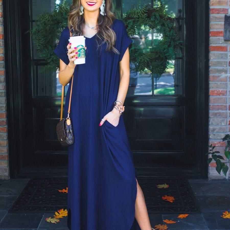 oversized short-sleeve t-shirt dress crafted from soft, stretchy material with a V-neckline, cuffed sleeves, side slits, and pockets on a solid navy fabric