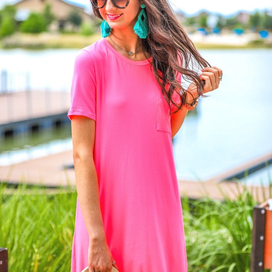 short sleeves made of super soft fabric with a round neckline, A-line style with a straight hemline, and a front chest pocket in neon pink