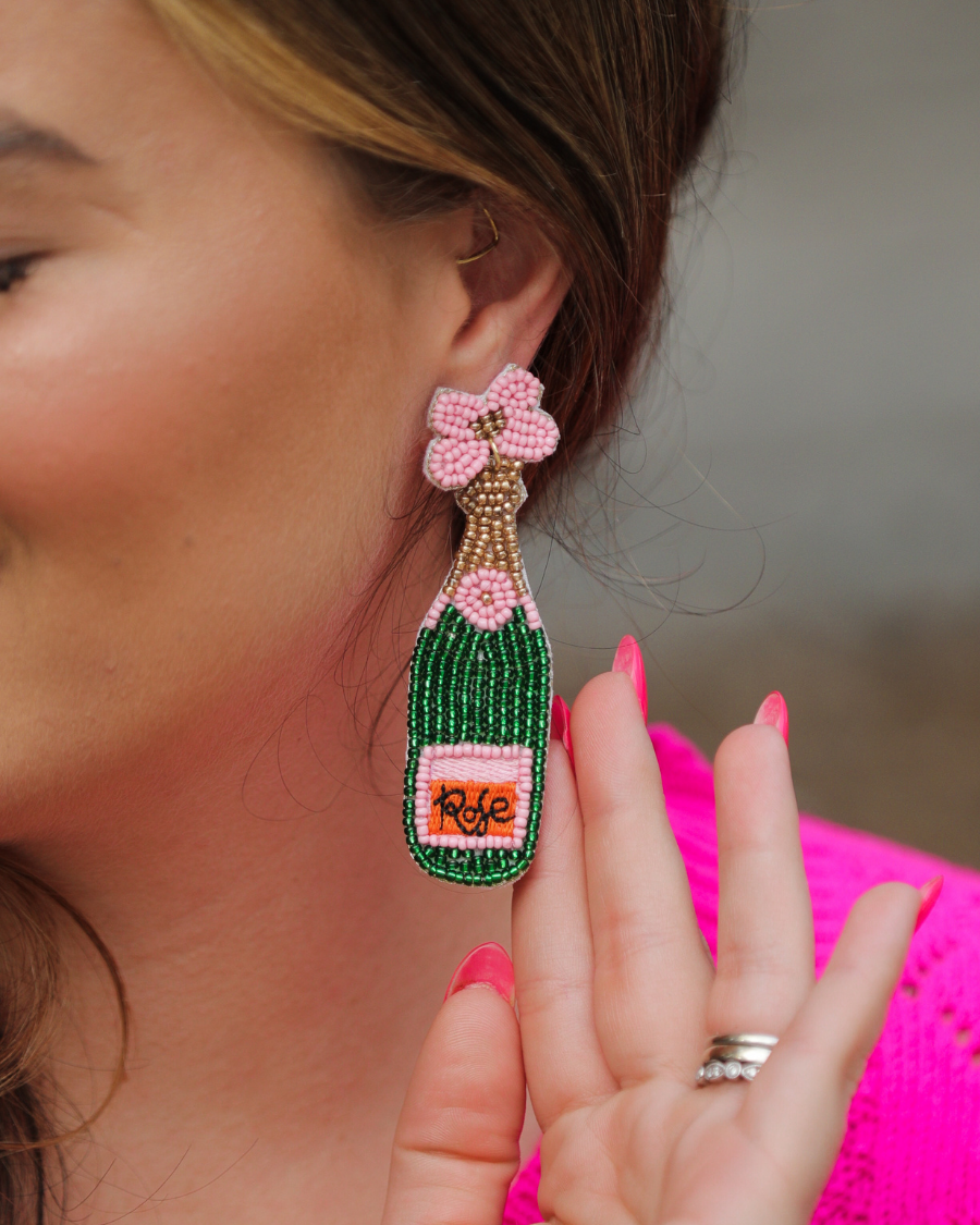 a flower stud adorned with gold, green, orange, and pink beads in the shape of a rosé bottle