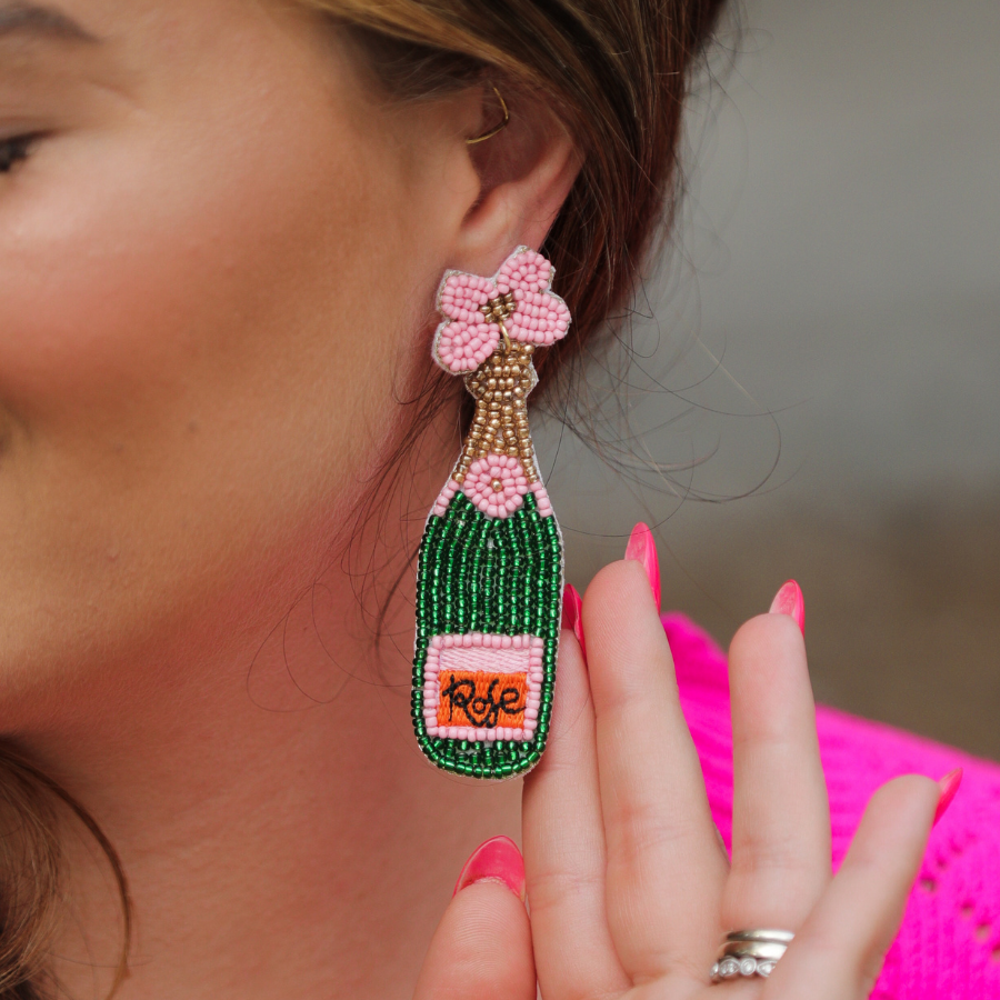 a flower stud adorned with gold, green, orange, and pink beads in the shape of a rosé bottle