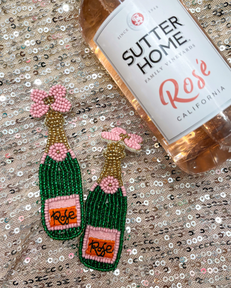 a flower stud adorned with gold, green, orange, and pink beads in the shape of a rosé bottle