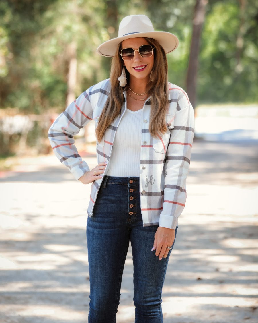 long sleeve shacket with fitted button closure cuffs, a button-down front, and a collared neckline on an ivory plaid print