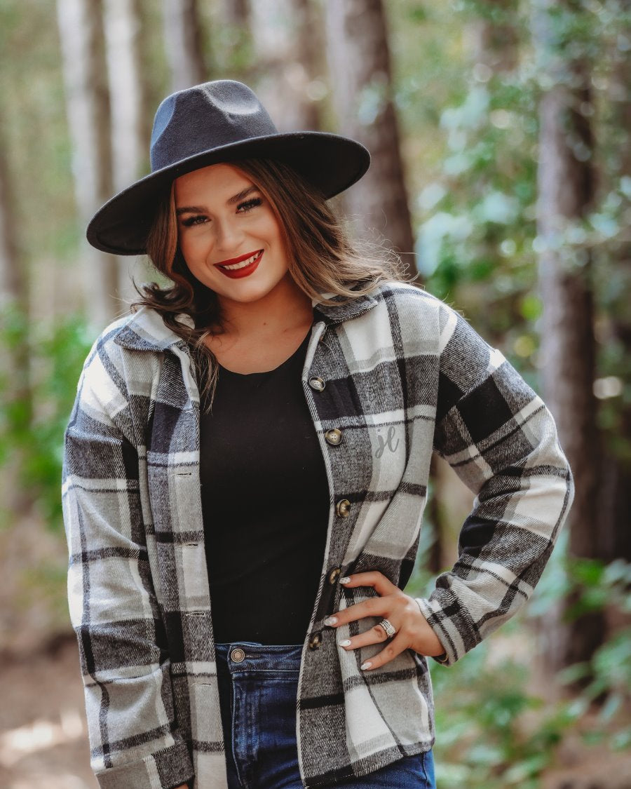 long sleeve shacket with fitted button closure cuffs, a button-down front, and a collared neckline on a black plaid print