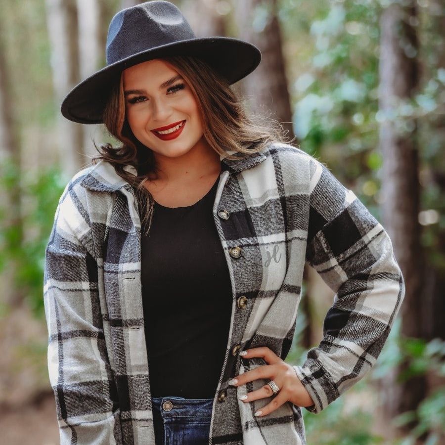long sleeve shacket with fitted button closure cuffs, a button-down front, and a collared neckline on a black plaid print