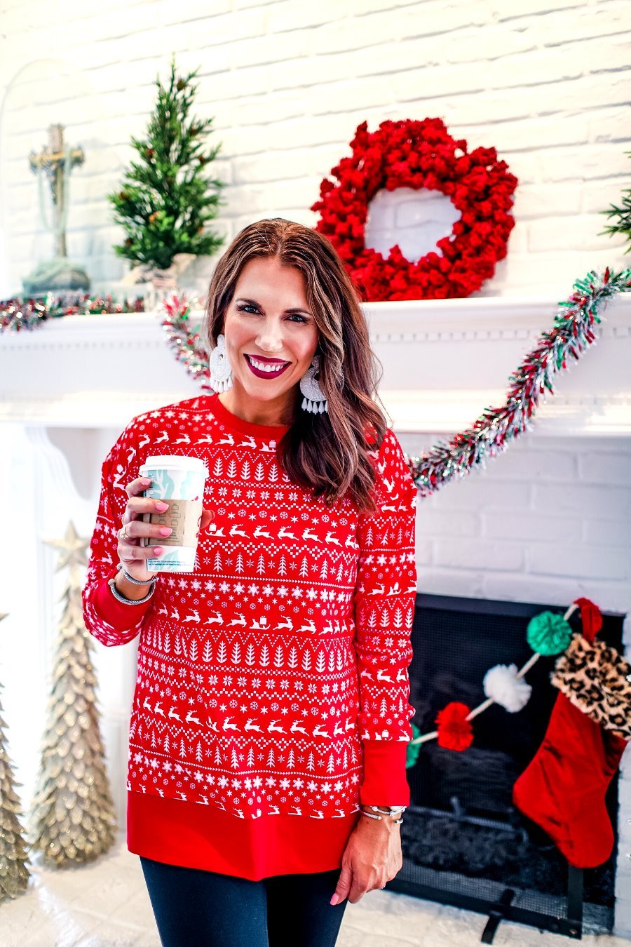 a red long-sleeve tunic made from comfy material with comfy material with a sublimation-printed Christmas pattern print (geometric designs, reindeer, Santa's sleigh, snowflakes, and trees) sublimation detail, ribbed accents (cuffs, neckline, and hem), side slits, and a relaxed fit