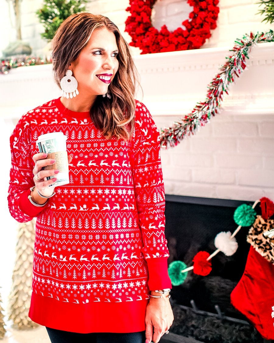 a red long-sleeve tunic made from comfy material with comfy material with a sublimation-printed Christmas pattern print (geometric designs, reindeer, Santa's sleigh, snowflakes, and trees) sublimation detail, ribbed accents (cuffs, neckline, and hem), side slits, and a relaxed fit