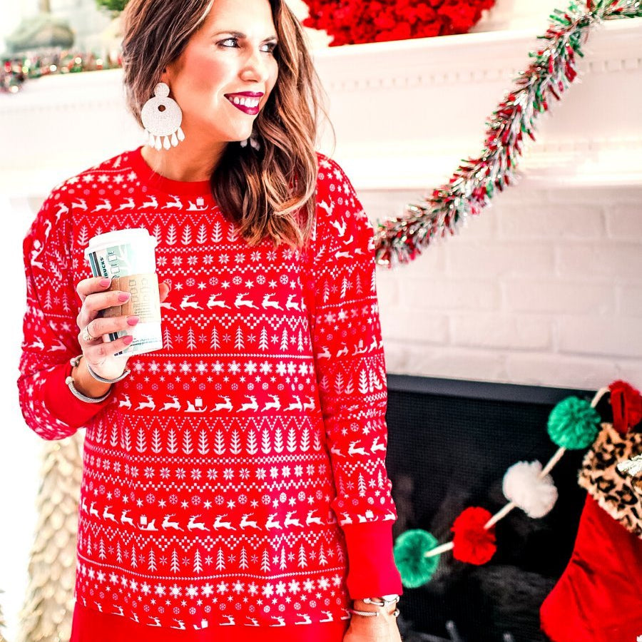 a red long-sleeve tunic made from comfy material with comfy material with a sublimation-printed Christmas pattern print (geometric designs, reindeer, Santa's sleigh, snowflakes, and trees) sublimation detail, ribbed accents (cuffs, neckline, and hem), side slits, and a relaxed fit