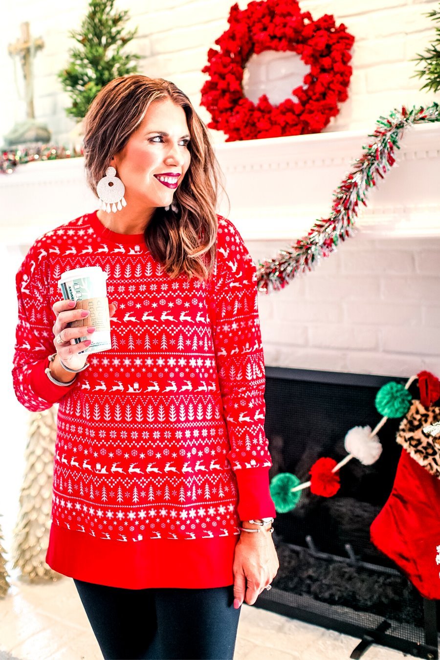 a red long-sleeve tunic made from comfy material with comfy material with a sublimation-printed Christmas pattern print (geometric designs, reindeer, Santa's sleigh, snowflakes, and trees) sublimation detail, ribbed accents (cuffs, neckline, and hem), side slits, and a relaxed fit