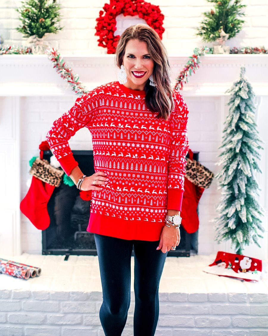 a red long-sleeve tunic made from comfy material with comfy material with a sublimation-printed Christmas pattern print (geometric designs, reindeer, Santa's sleigh, snowflakes, and trees) sublimation detail, ribbed accents (cuffs, neckline, and hem), side slits, and a relaxed fit