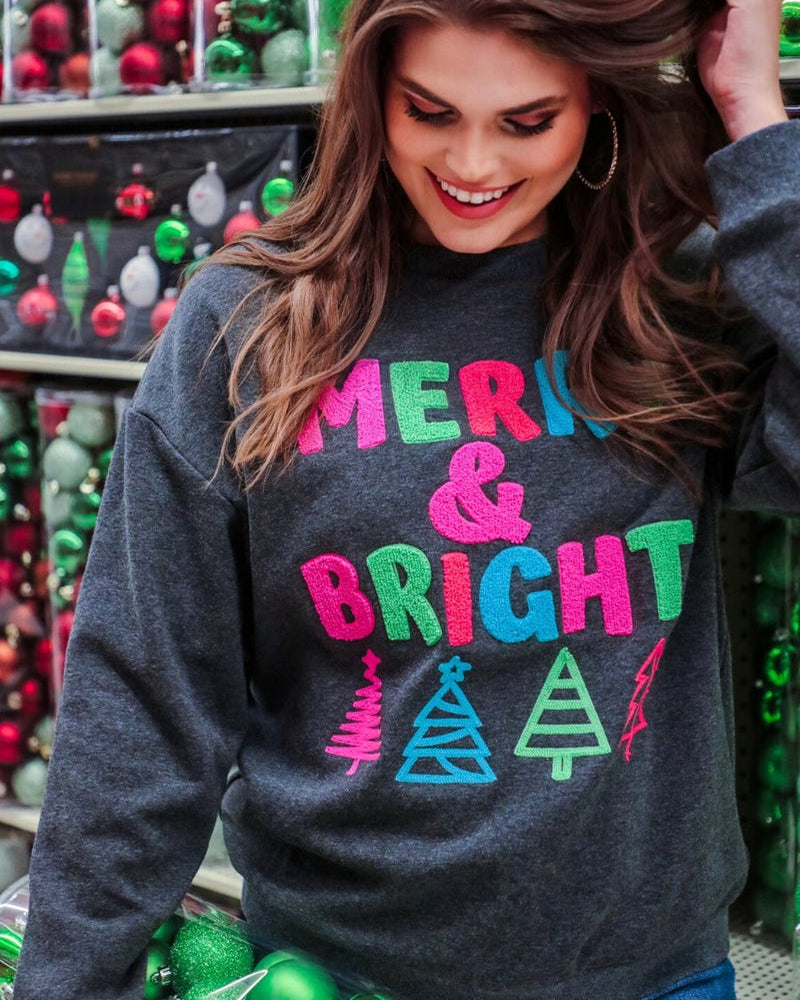 a charcoal long-sleeve sweatshirt with a fuzzy inside, sewn on color chenille letters, and Christmas tree patches