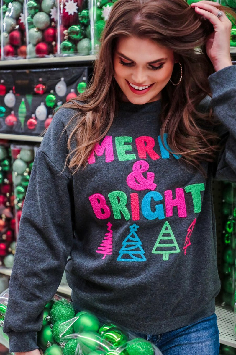 a charcoal long-sleeve sweatshirt with a fuzzy inside, sewn on color chenille letters, and Christmas tree patches