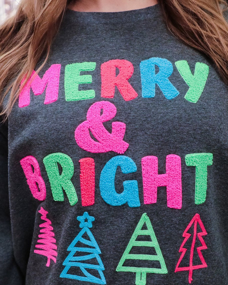 a charcoal long-sleeve sweatshirt with a fuzzy inside, sewn on color chenille letters, and Christmas tree patches