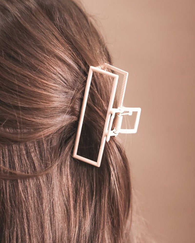 a metal neutral rectangular claw clip with a secure hold that reduces breakage in peach